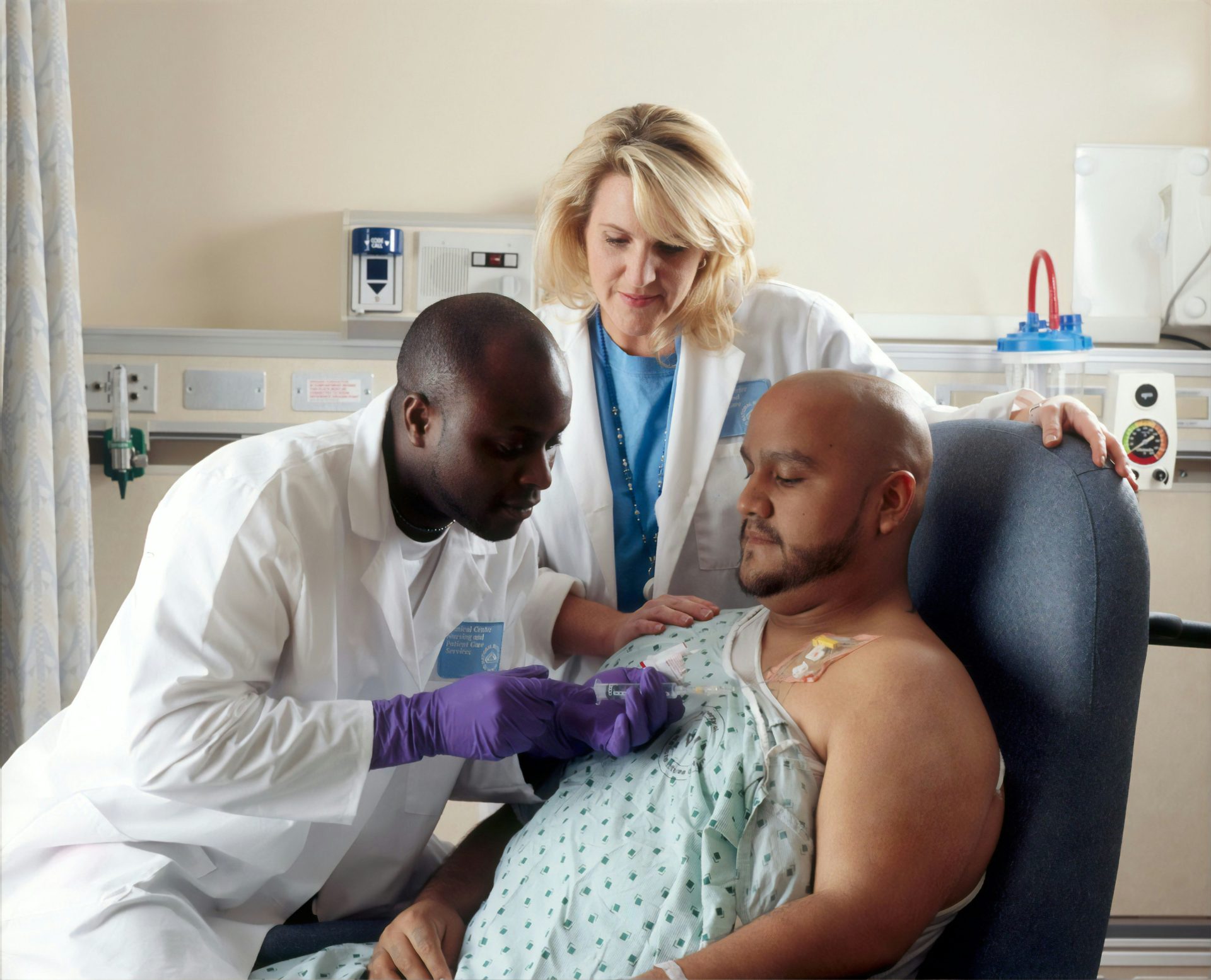 Doctor administers injection to patient in hospital room.